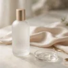 Flacon dépoli élégant et goutte de gel transparent sur marbre ivoire, ambiance bien-être premium