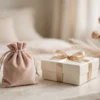 Pochon en velours rose poudré et coffret discret sur une table de chevet, ambiance douce et élégante